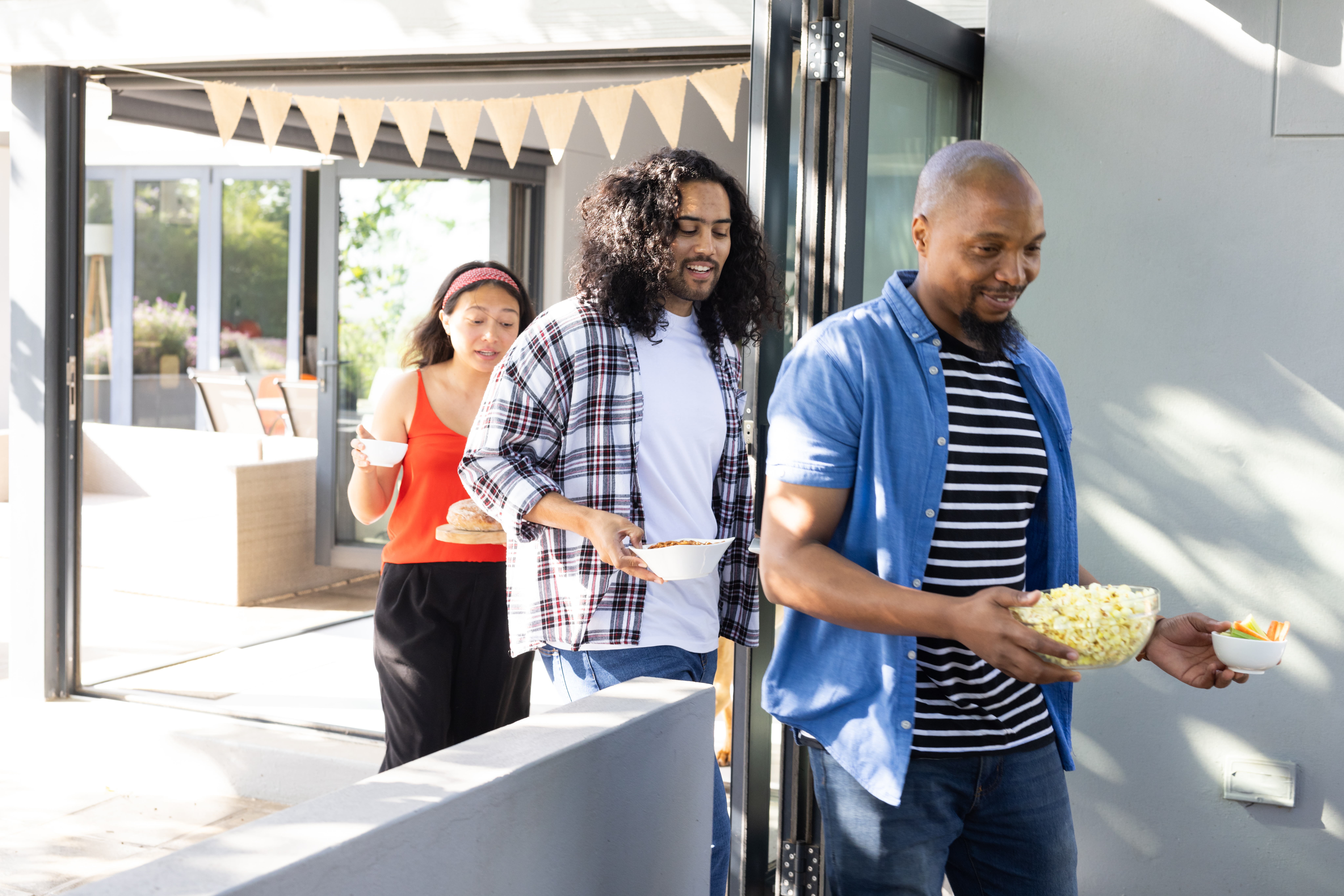 Friends carrying snacks and drinks outdoors, enjoying sunny celebration together. Party, picnic, beverages, summer, gathering, happiness food truck créole en action en Guadeloupe